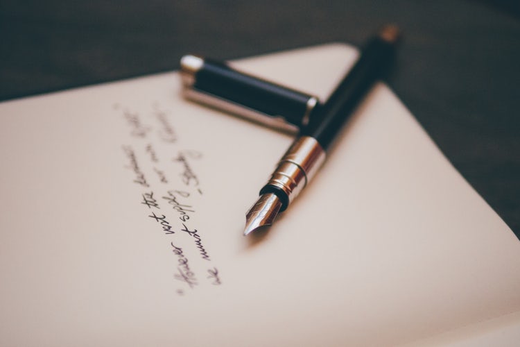 Fountain pen on writing stationery photo